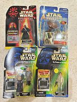 All four carded Star Wars figures laid out: Darth Maul, Yoda, Ugnaughts, Princess Leia