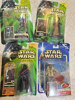 Group shot of four sealed Star Wars figures on floor