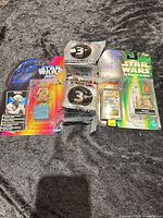 Four Star Wars items laid out: two carded Yoda figures and two sealed Taco Bell mirror cubes