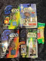 Four carded Yoda figures and sealed Yoda PEZ dispenser laid out on black surface