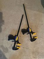 Two Quick-Grip bar clamps on floor