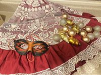 Tree skirt, leather mask and ornaments grouped