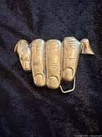 Front view of solid brass hand-shaped belt buckle