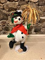 Full view of Annalee snowman on counter showing self-stand and tag