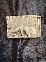 Front view showing full polar bear and sunburst relief on buckle