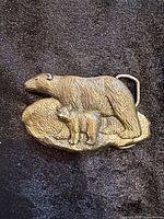 Front view of metal belt buckle showing adult and cub polar bears design