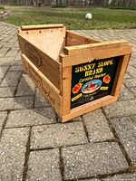 Overall view of open wood crate showing side branding and interior