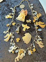 Entire lot laid out showing necklace, pins, pendant, ornament, coin charm and star