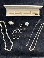 Full lot showing all jewelry pieces laid out on black surface