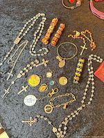 Full group shot of all devotional jewelry pieces on black surface