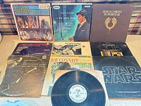 Overview of all nine album covers and one vinyl disc