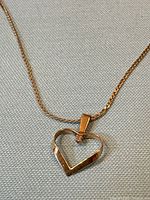 Heart pendant on chain showing diamond and gold tone