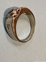 Profile view of 18K white gold signet ring showing black stone bezel and diamond accent, interior hallmark visible