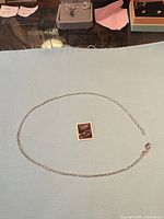 Full view of sterling silver rolo chain necklace in circle layout with scale stamp