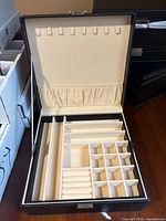Jewelry box open showing removable tray with ring rolls and compartments