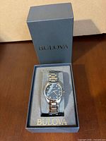 Watch seated in branded Bulova box with cushion