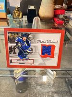 Front view of card on stand showing player image, patch, title and set details