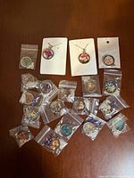 Overview of all pendants; three on cards, remainder in bags