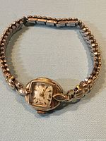 Full view of wristwatch with stretch bracelet laid flat