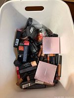 Bin of assorted boxed makeup items; shows quantity and variety