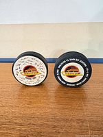 Front view of both pucks standing on edge
