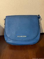 Front view showing logo, flap, leather texture