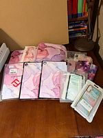 Overview of all cases including three tablet covers, sleeve, packaged and loose phone cases