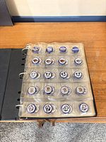 Binder open showing full page of bottle caps