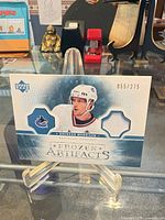 Front of card showing Brendan Morrison image, Vancouver Canucks logo, jersey swatch window and serial number 055/275