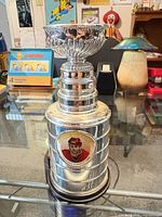 Full view of silver-tone Stanley Cup style trophy on glass table