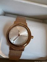 Front view of Skagen rose gold mesh wristwatch in box showing dial and mesh band