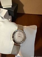Front view of Skagen watch on cushion showing dial, bezel, mesh band