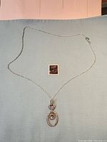 Full view of necklace laid flat showing chain and pendant