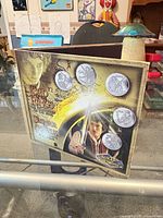 Front view of folded display booklet with five coins inserted