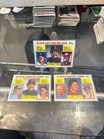 Two Topps career leader baseball cards displayed in top loaders on table surface