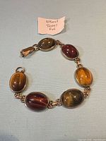 Full view of bracelet laid flat showing six tiger's eye stones and clasp