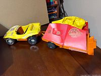 Yellow dune buggy, orange trailer with red vinyl sides and yellow canopy overall view