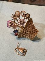 Front view of basket and insect brooches