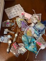 Tabletop view of assorted jewelry, organza bags, watches and organizer