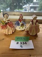 Three Royal Doulton figurines grouped on table