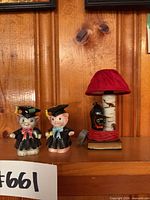Front view of both graduate cat figurines and the mini cat lamp on shelf