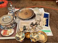Wide view of entire lot showing trays, bowl, platter, knives, goblets, tankard, small vessels