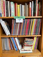Three shelves filled with cookbooks of various types