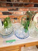 Assorted coloured and clear glassware grouped on countertop