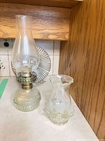 Oil lamp and hurricane candle holder on countertop