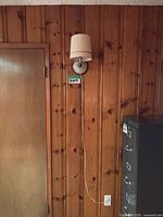 Front view of wall sconce on paneled wall