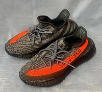 Left side view of both sneakers showing orange stripe and SPLY-350 text