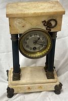 Front view showing marble case, dial, columns, brass wreath