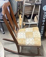 side view of wooden nursing rocking chair showing curved rockers and upholstered seat