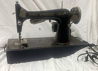 Full left-side view showing machine profile, motor, hand wheel, cords